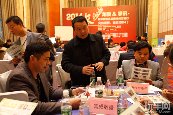 图为参会厂家代表向现场4S集团、代理商介绍产品