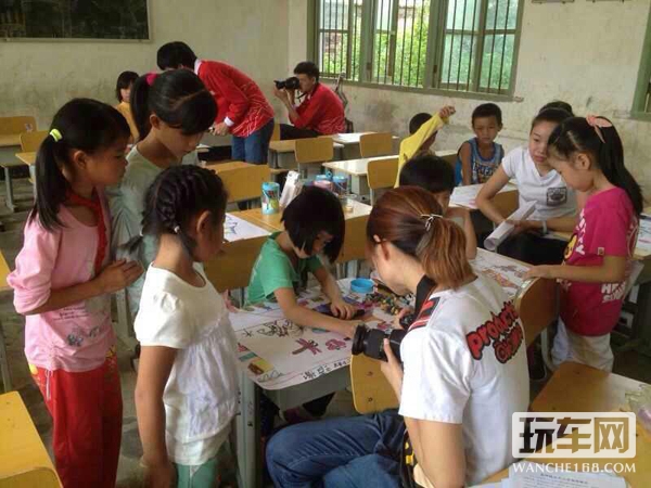 这个小女孩画的很认真，引来其他小女孩的围观